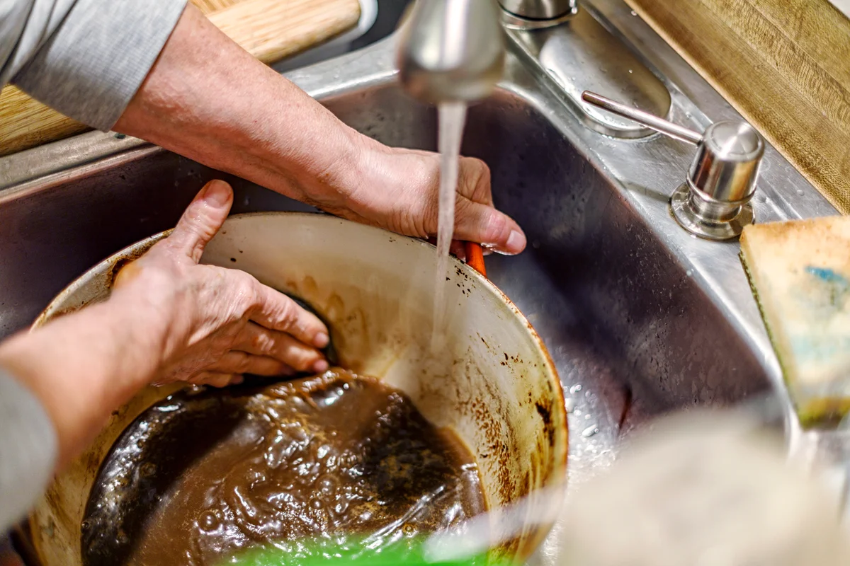 Scrubbing Burnt Food Residue Out of Dutch Oven Cooking Pan