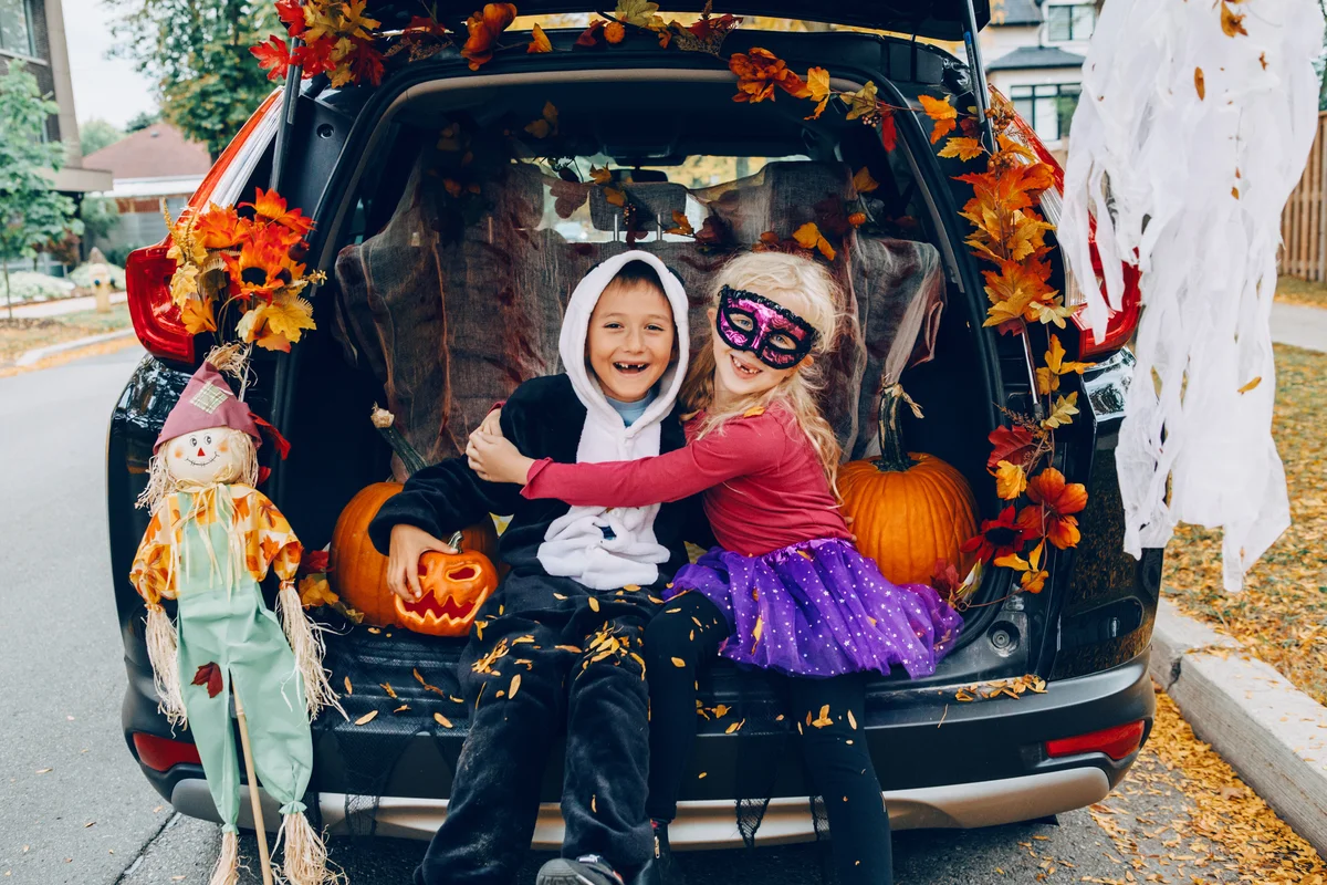 brother and sister in back of minivan for Halloween Trunk or Treat