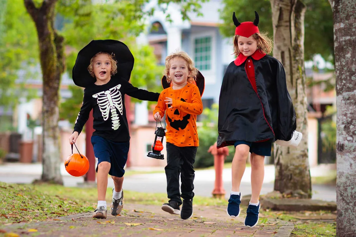 three children Trick or Treating on Halloween