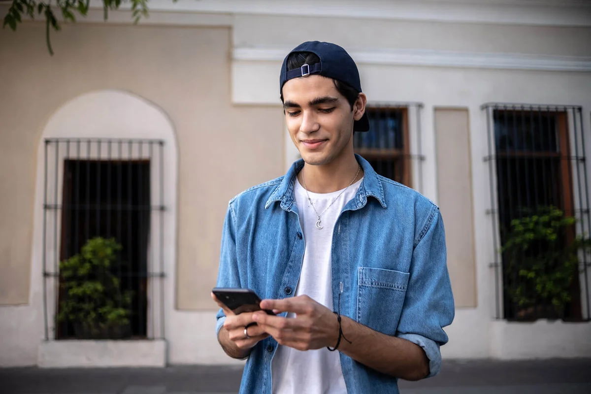 Teenager boy using the mobile phone outdoors