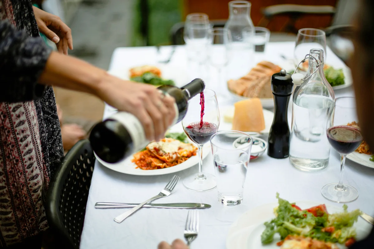 Family dinner with lasagna and red wine