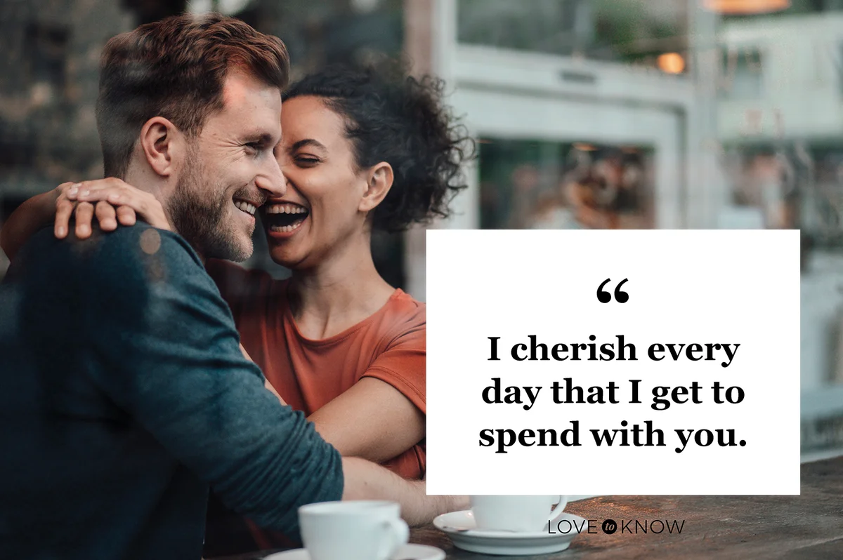 Cheerful woman sitting with arm around on man at cafe