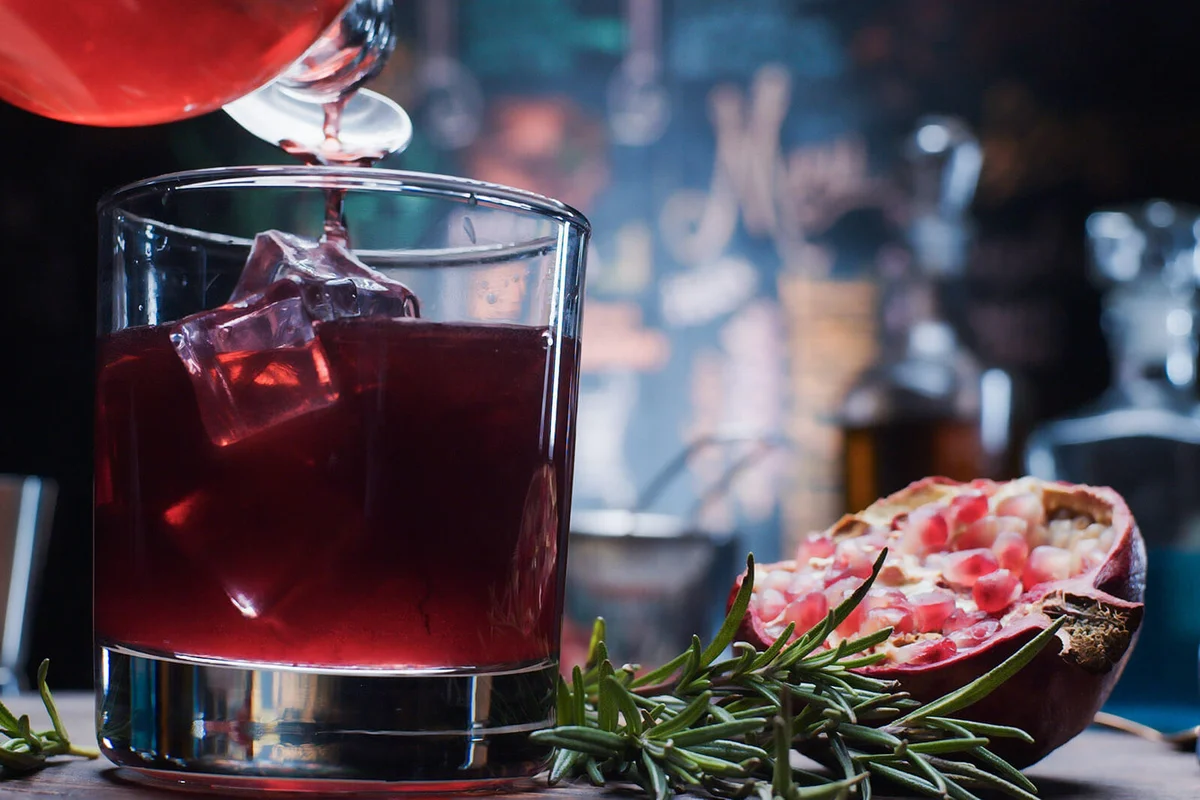 Vlogger is showing how to make layered drink with pomegranate and edible glitter