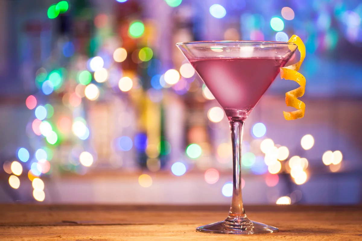 Glasses of blackjack cocktail on a bar lights background