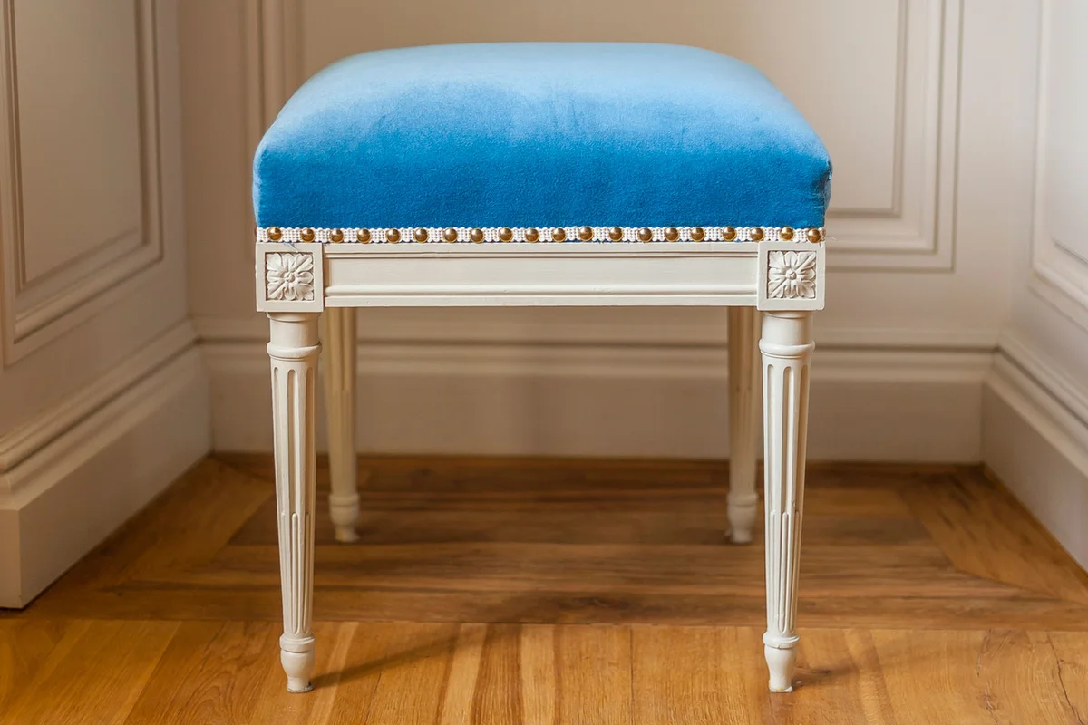 vintage white wood footstool with carved legs and blue upholstery