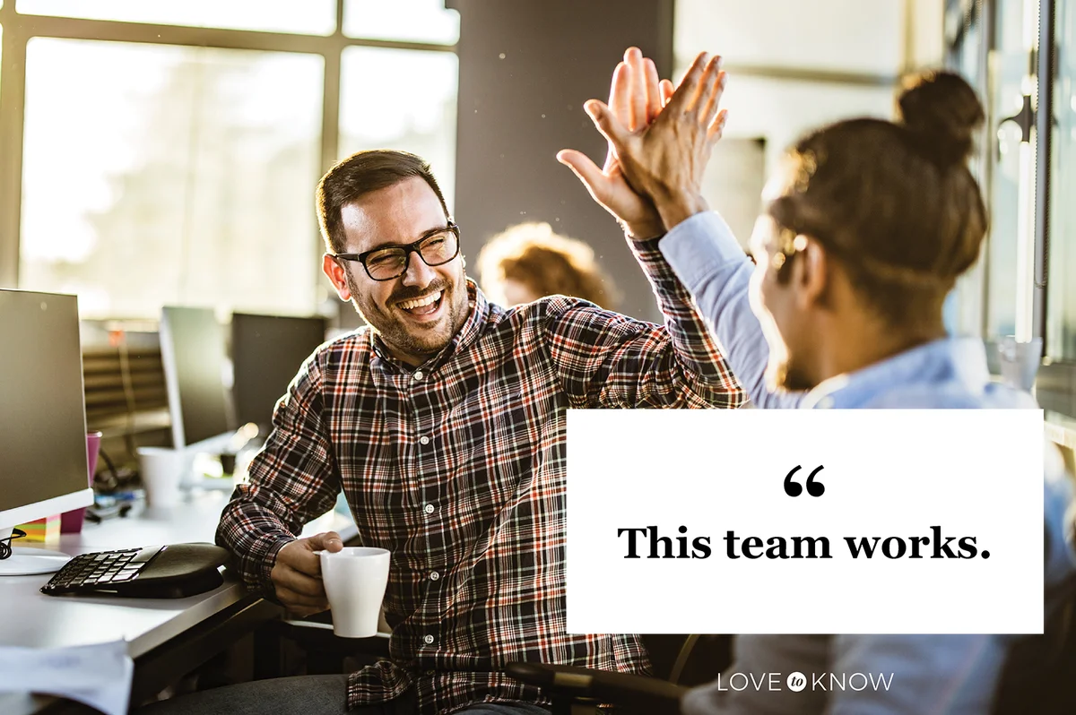 Co-workers giving each other high-five in the office
