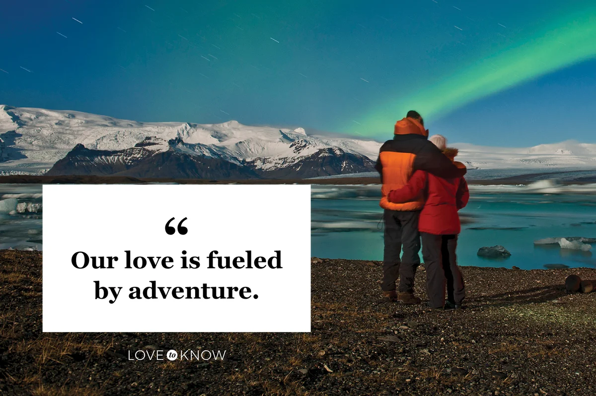 Couple outside of their tent looking at Northern Lights