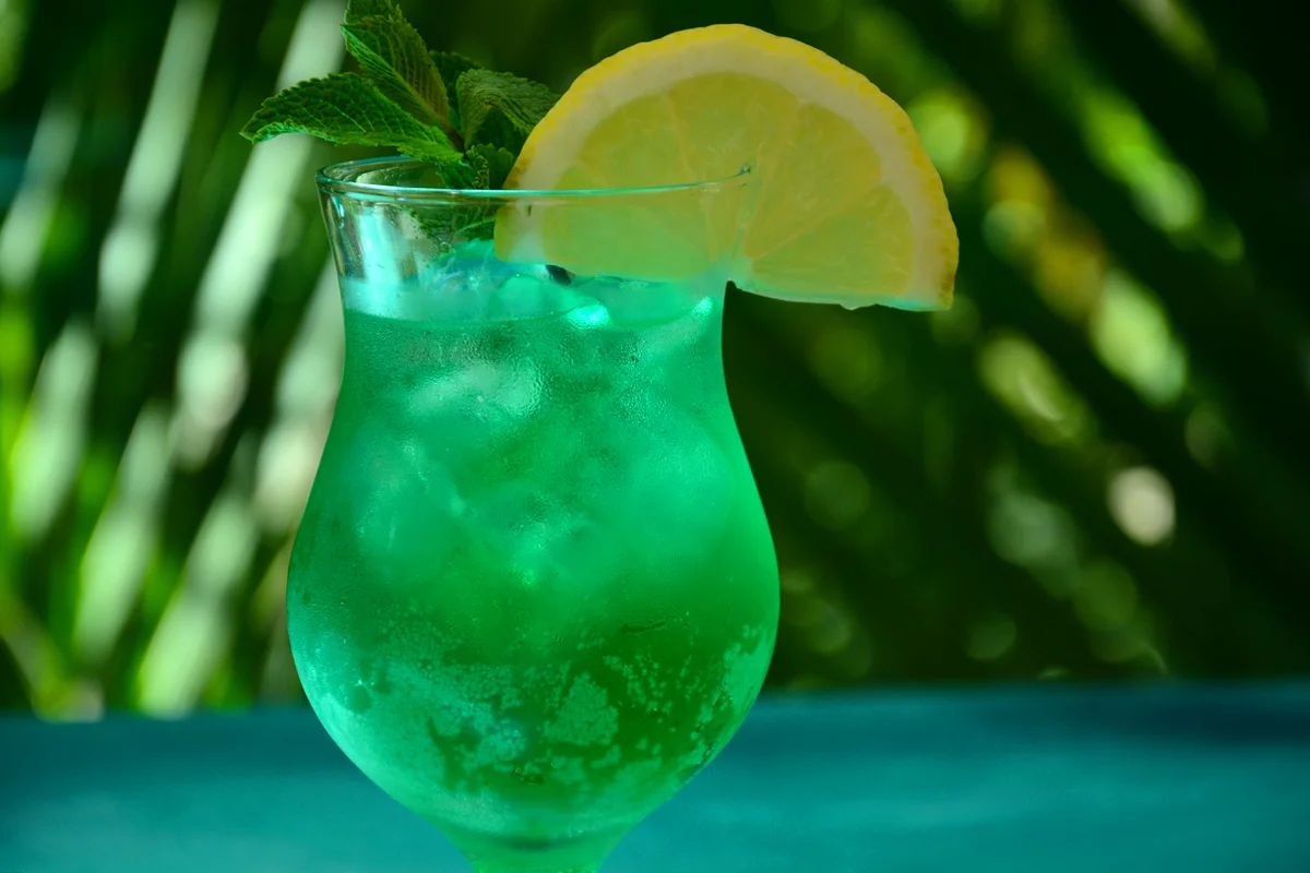 Glass of cocktail green fairy with lemon