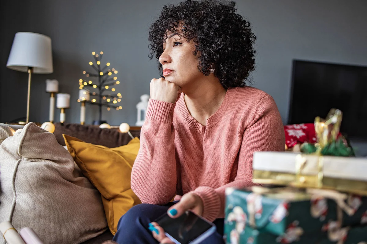 sad woman looking out window during holidays