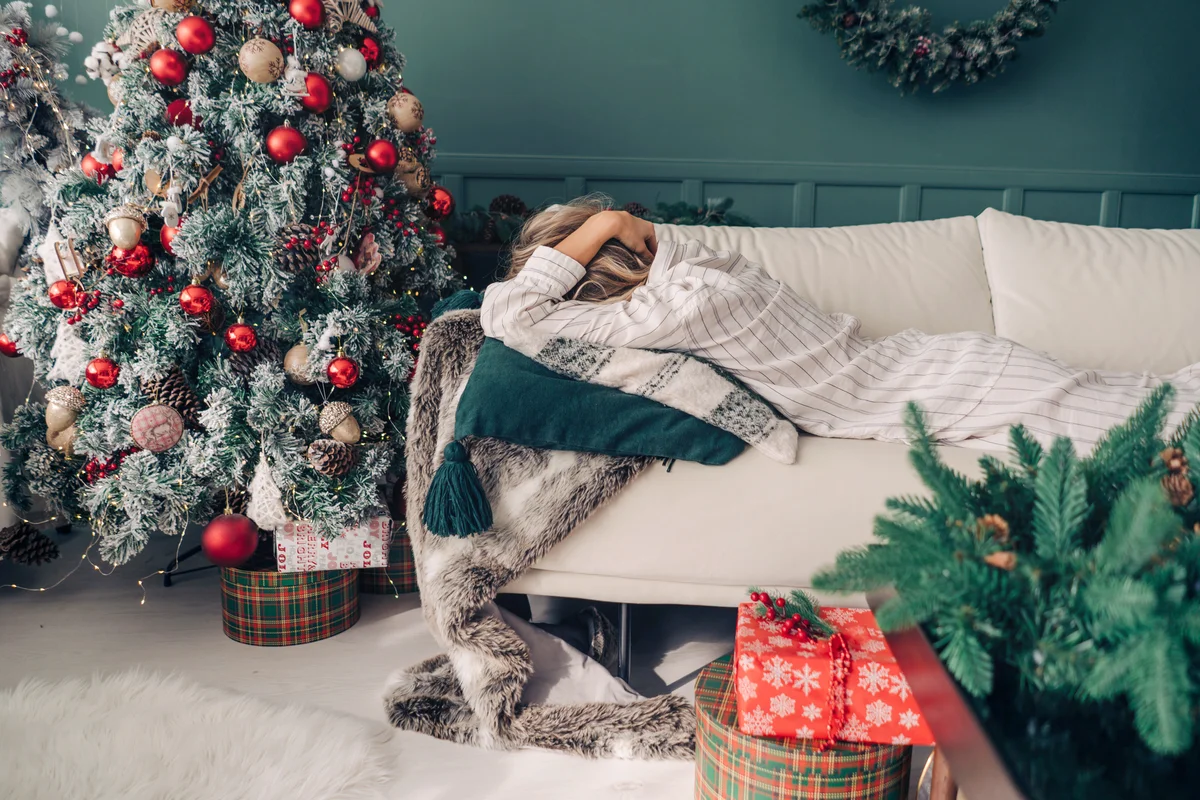 Sad Woman Buried Her Head In Pillow While Lying On Sofa In Christmas
