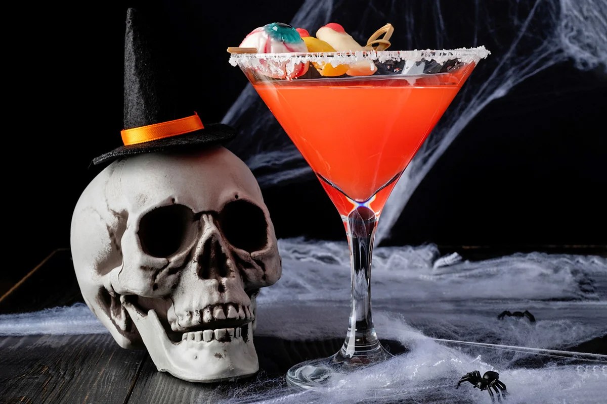 skull with witch hat beside a Halloween cocktail