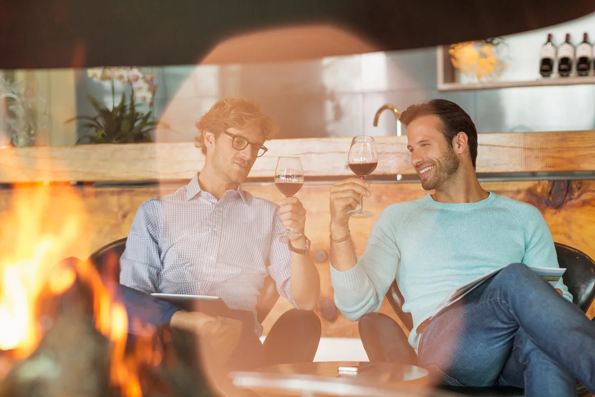 couple drinking wine by fireplace