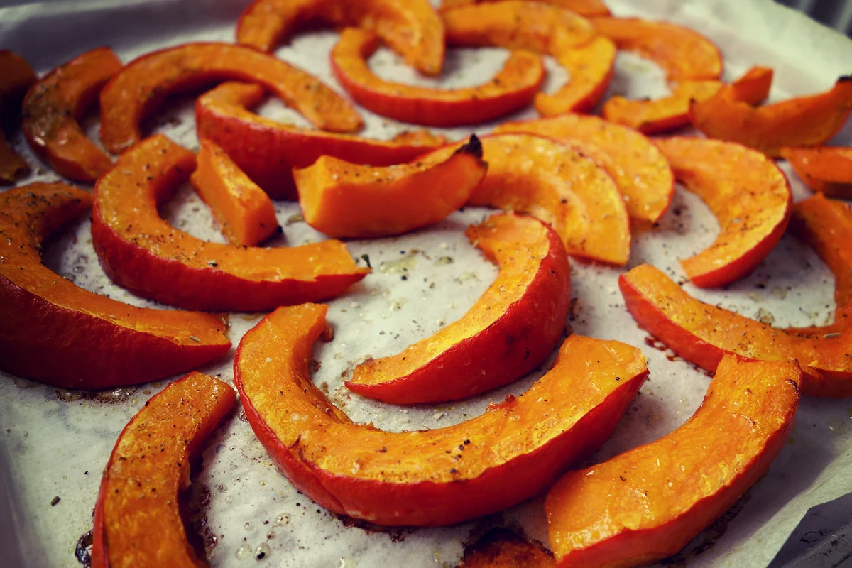 Delicious, roasted hokkaido pumpkin for Halloween on baking paper