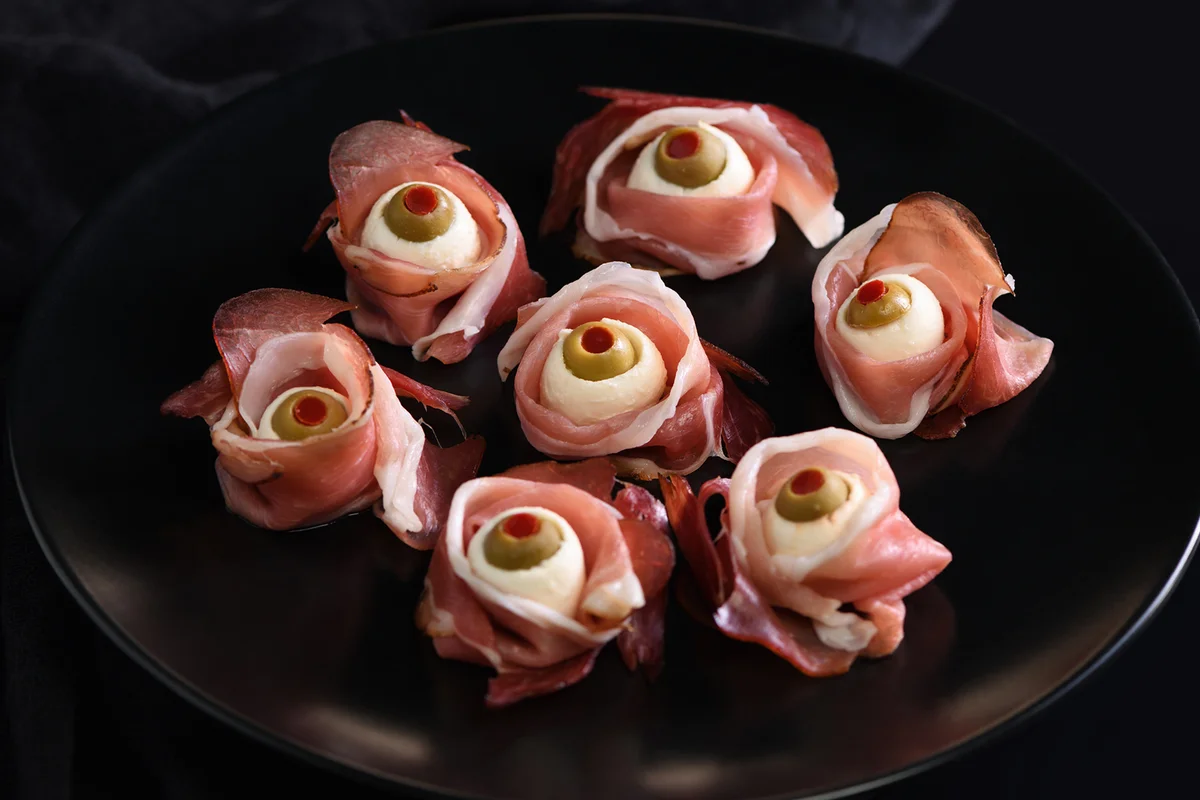 Eyeballs cooked from ham with mozzarella, olives stuffed with red pepper