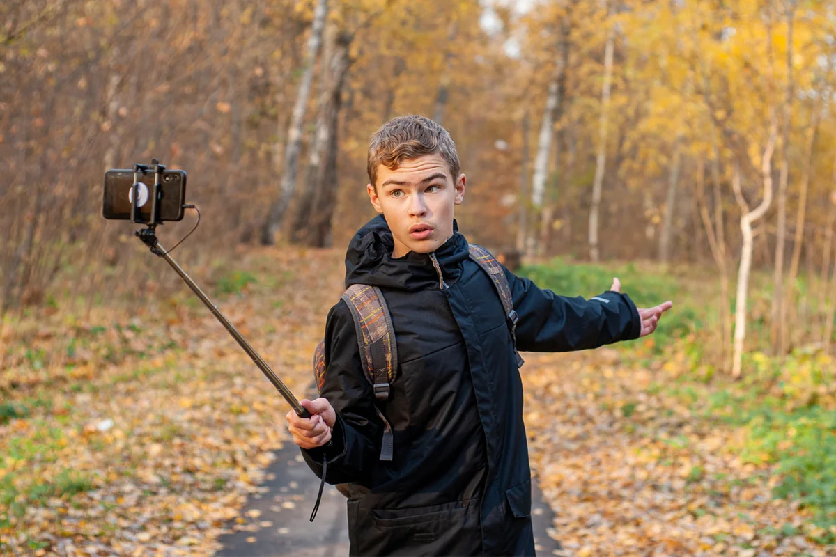 boy recording himself making scary movie in the forest