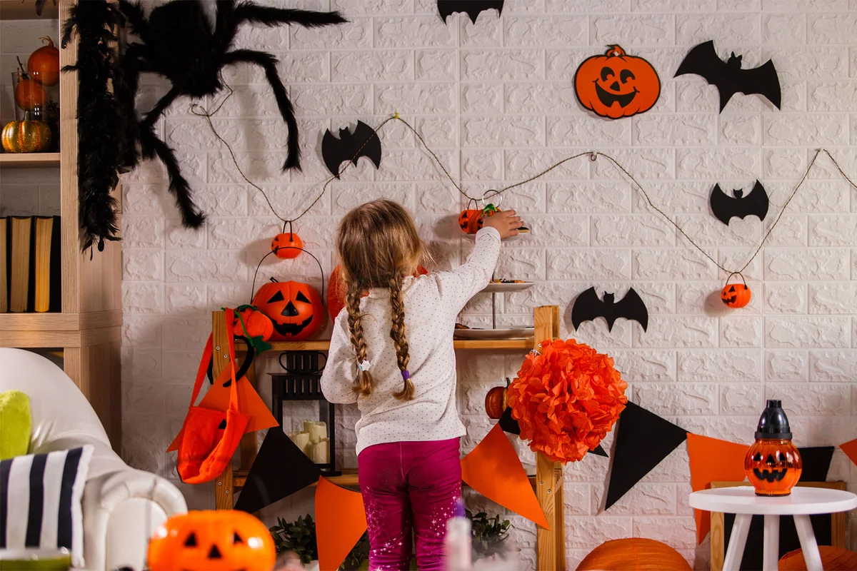 girl decorating house for Halloween