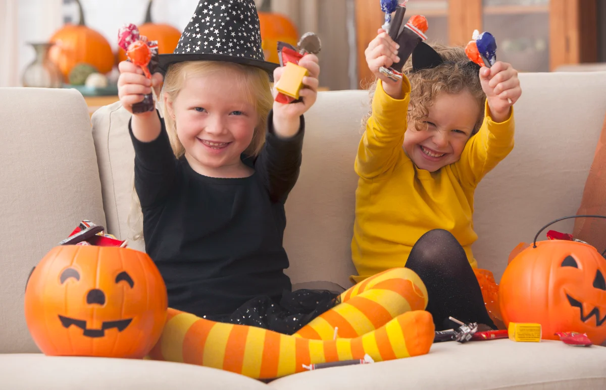 Girls in Halloween costumes eating candy