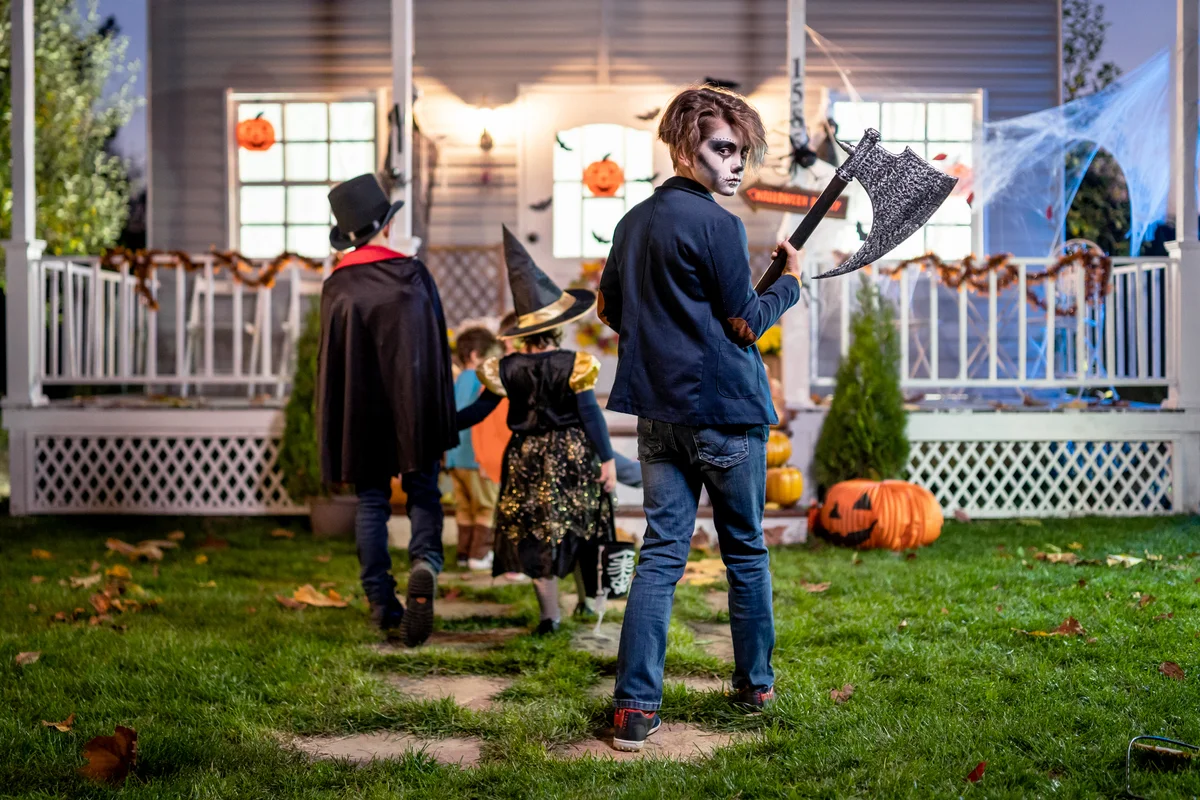 Young kids trick or treating at night during Halloween
