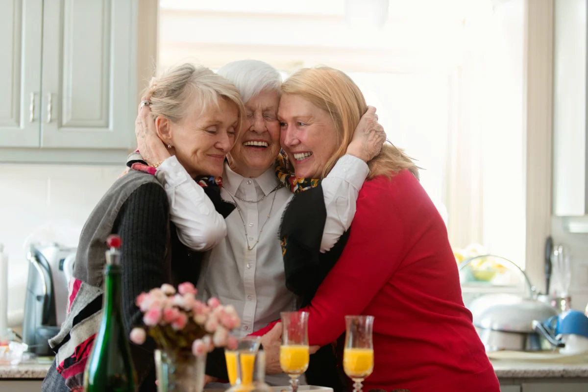 Elderly woman hugging her two daughters
