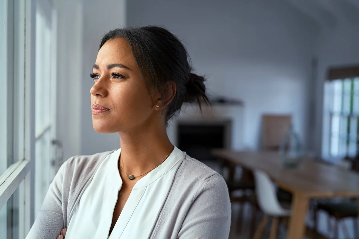 Thoughtful woman looking outside window