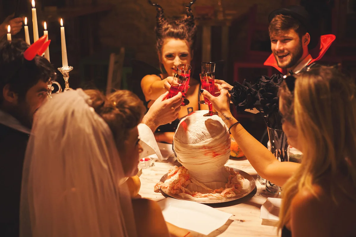 friends in costumes toasting red wine at Halloween Birthday party