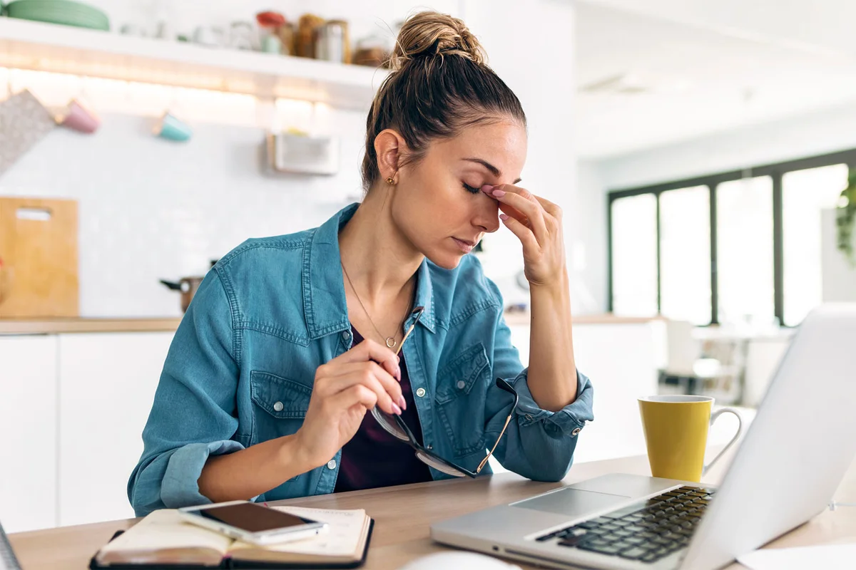 woman sitting at computer feeling stress of job