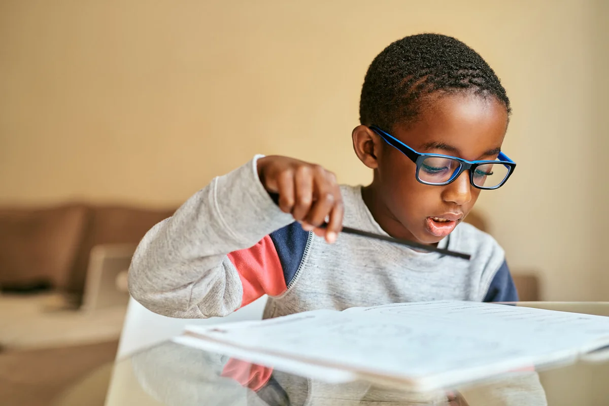 adorable little boy doing his schoolwork at home