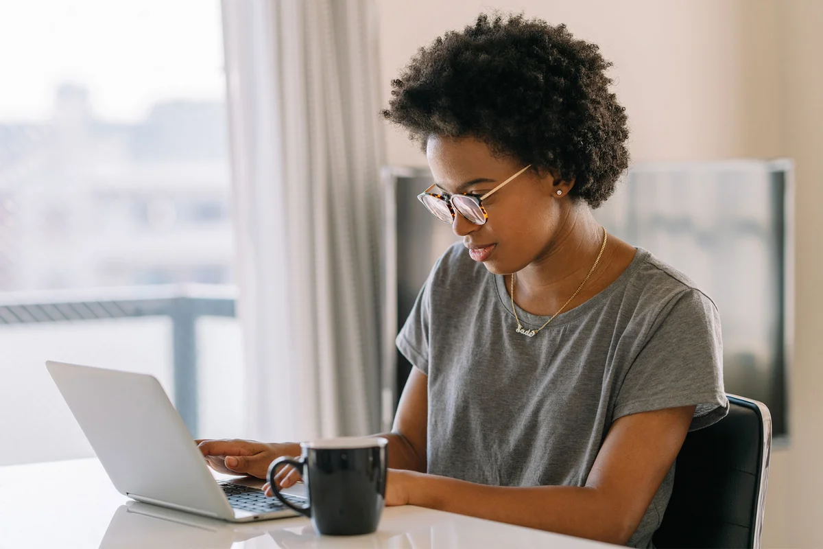 woman typing obituary on laptop