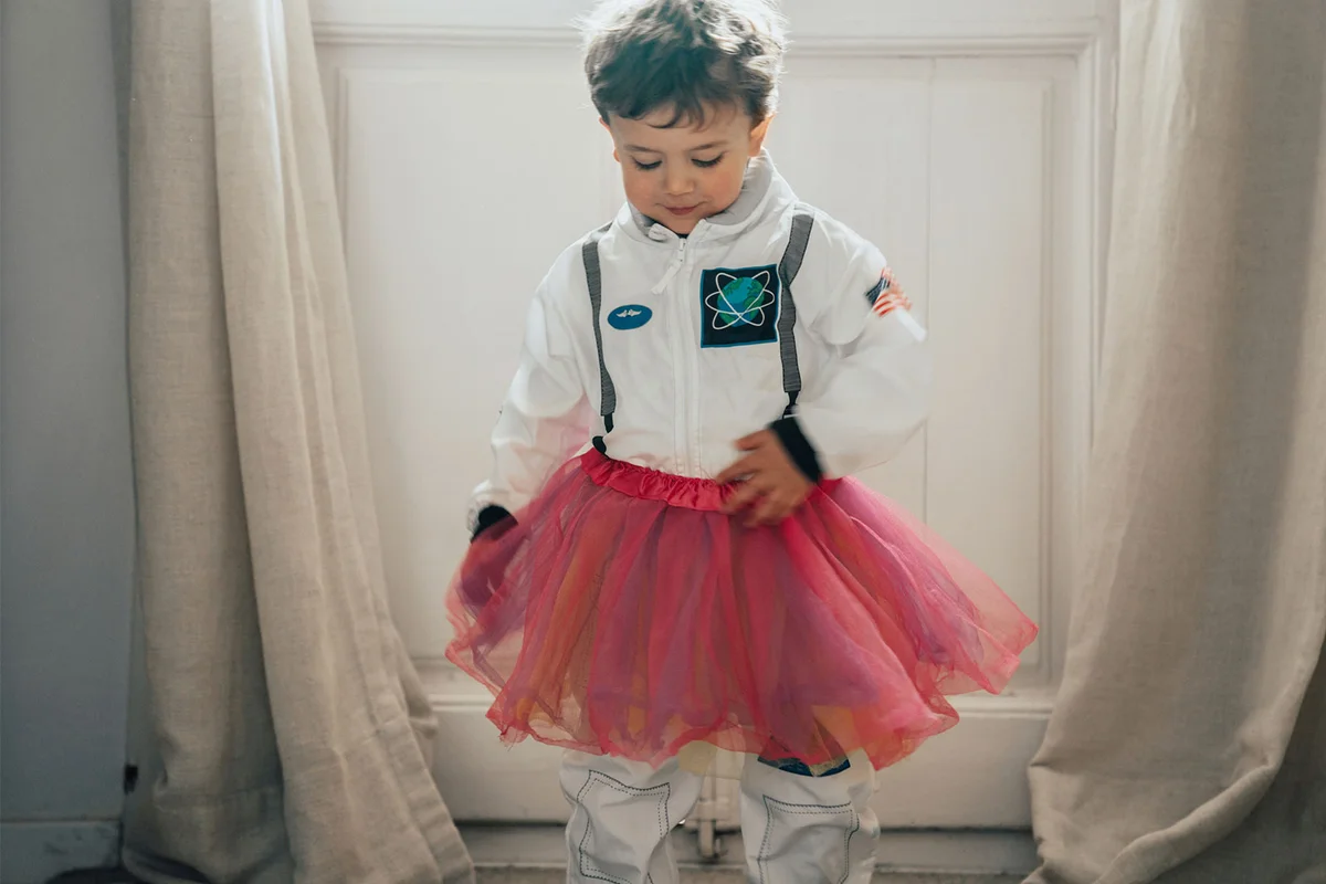 child playing make believe in astronaut costume with tutu