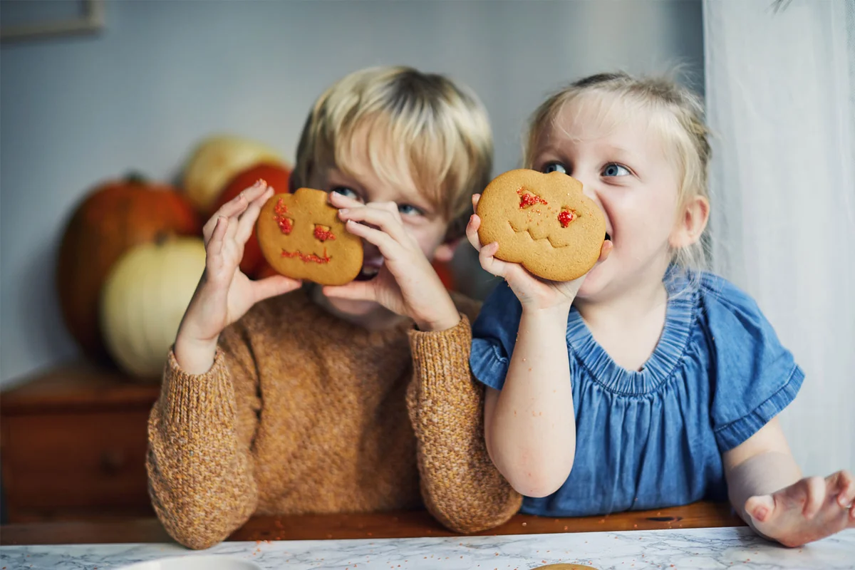 toddlers decorating Halloween cookies