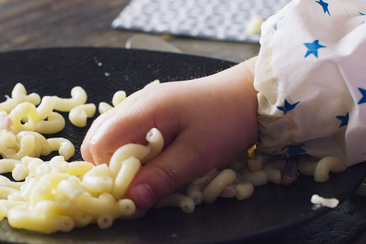 toddler touching pasta