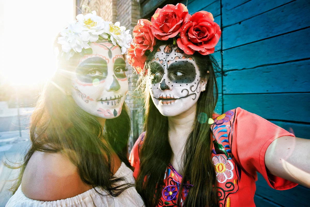 Day of the Dead people wearing traditional makeup on street