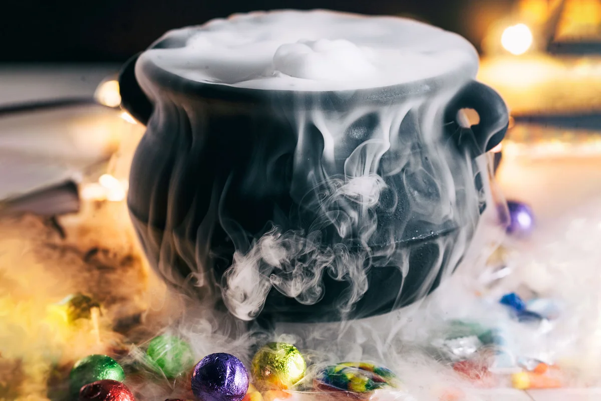 cauldron with dry ice and candy on table for Halloween table decoration