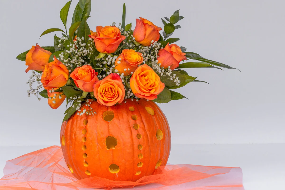 carved pumpkin with flowers for halloween party table decor