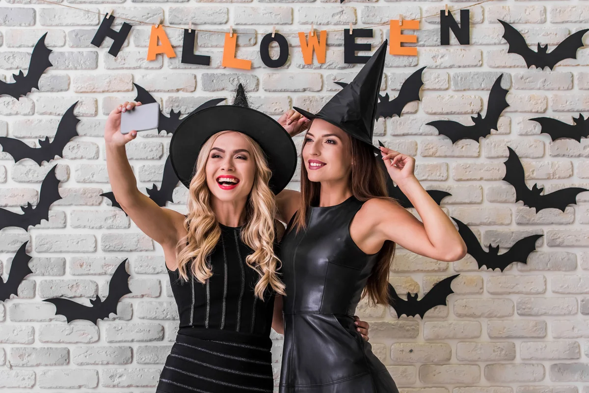 People in costumes taking selfie at Halloween Photo Booth
