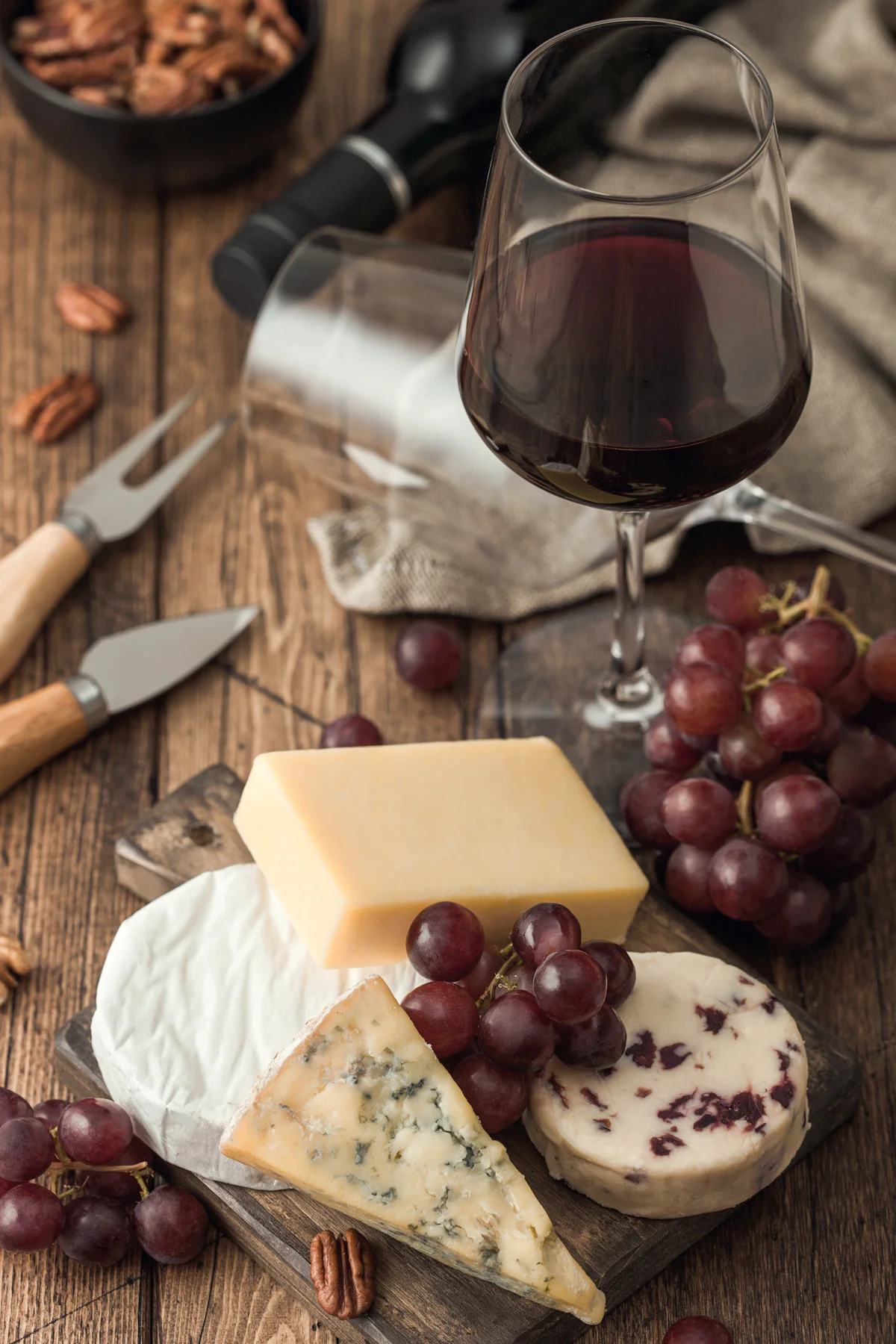 Glass of red wine with selection of various cheeses