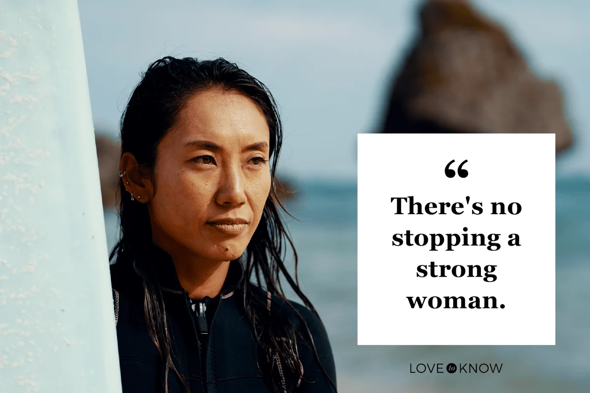 Portrait of a mature female athlete with her surfboard standing on a beach in Japan