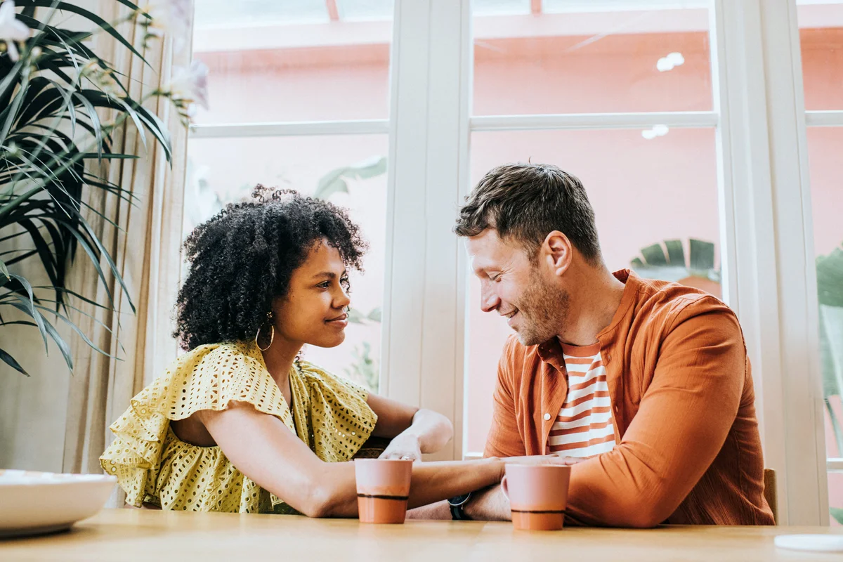 Young couple looks very much in love as they sit at a dining table