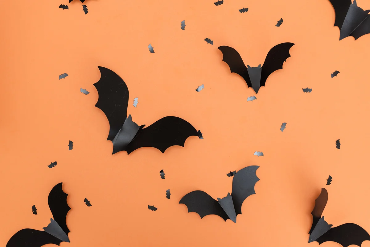 Black paper bats on orange background