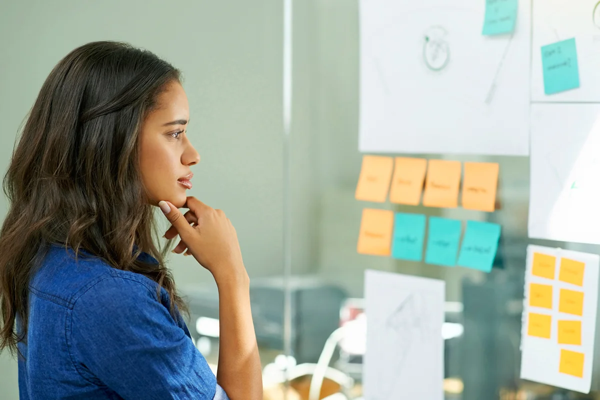 Young woman brainstorming with sticky notes at work