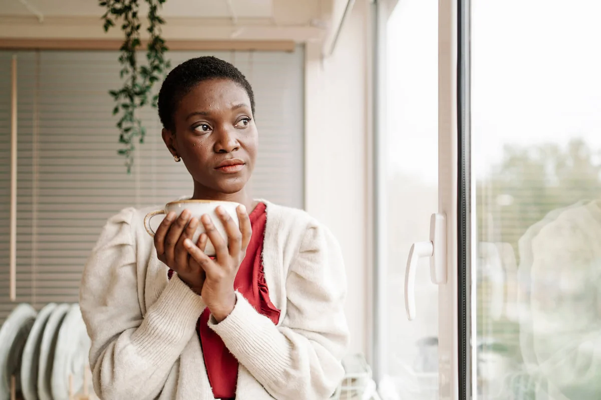 woman thinking and looking out the kitchen window