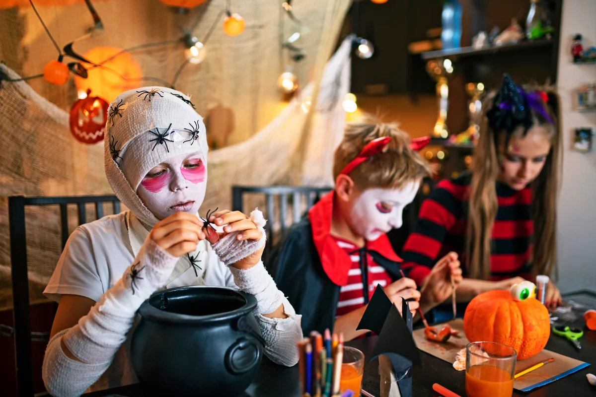 Kids crafting trick or treat baskets for Halloween