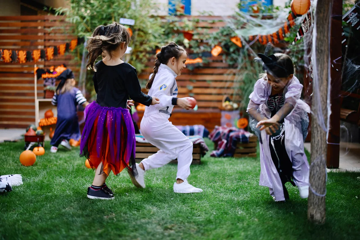 Group of happy kids or playing tag it game and running in the garden