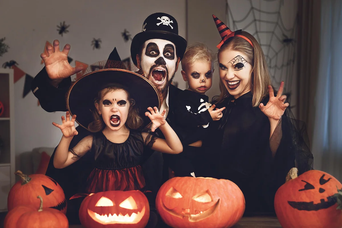 Happy family mother father and children in costumes and makeup on Halloween