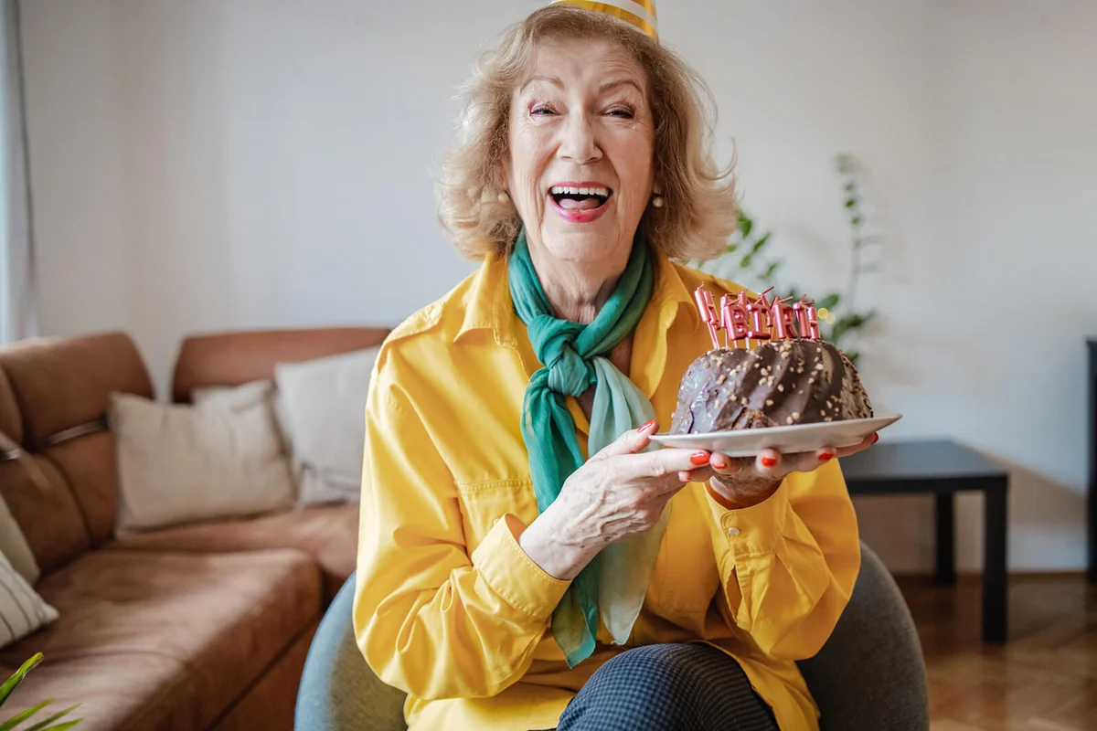 Portrait of senior woman holding birthday cake