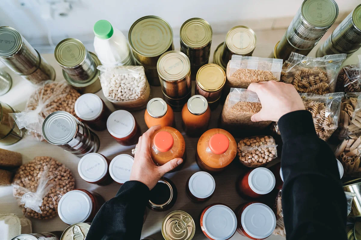 Woman is rearranging the nonperishable food at the food bank