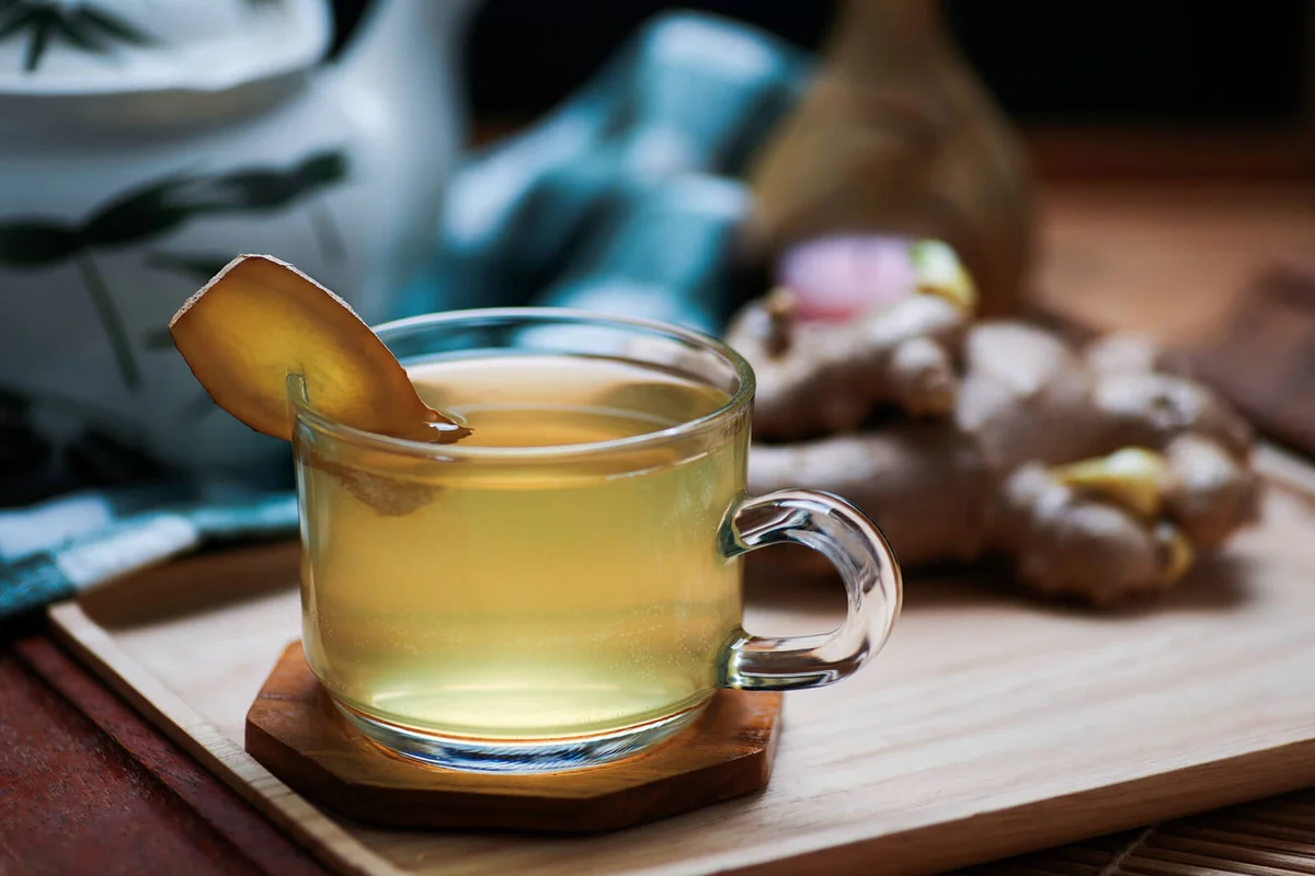 A cup of ginger tea on the wooden tray