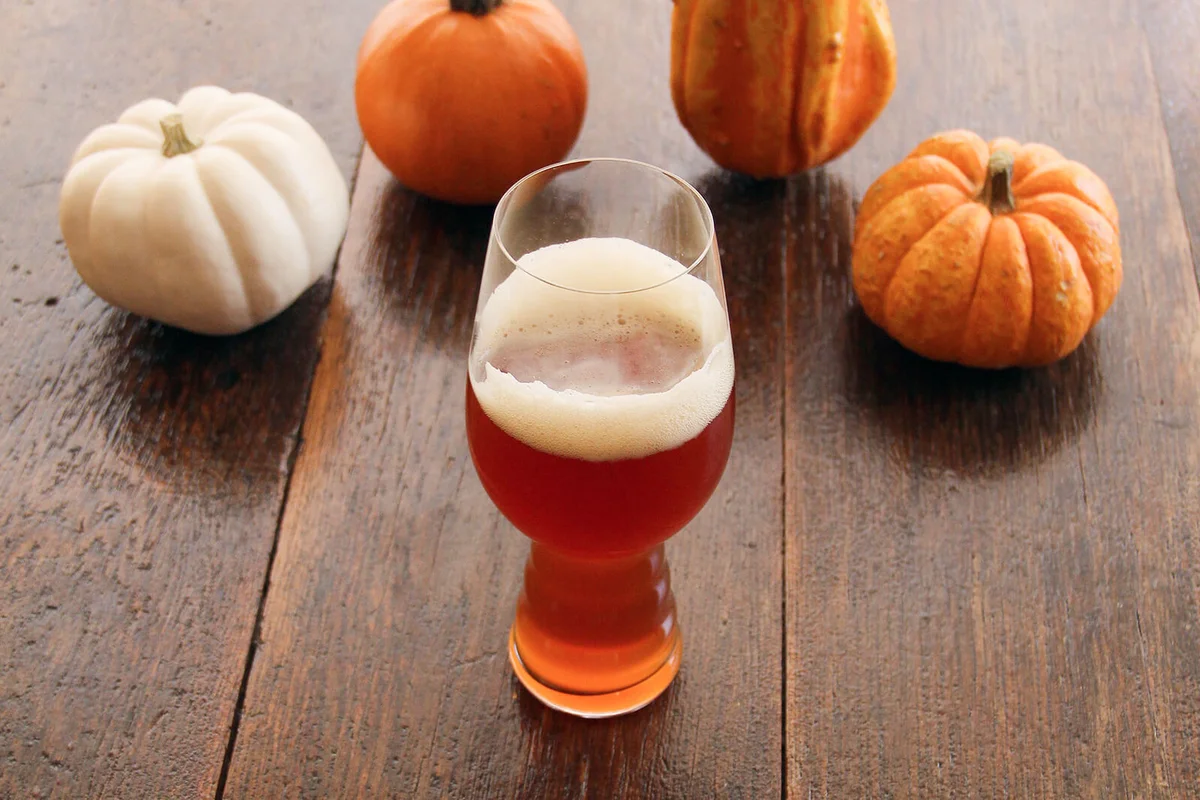High Angle View Of Drink In Glass By Pumpkins On Table
