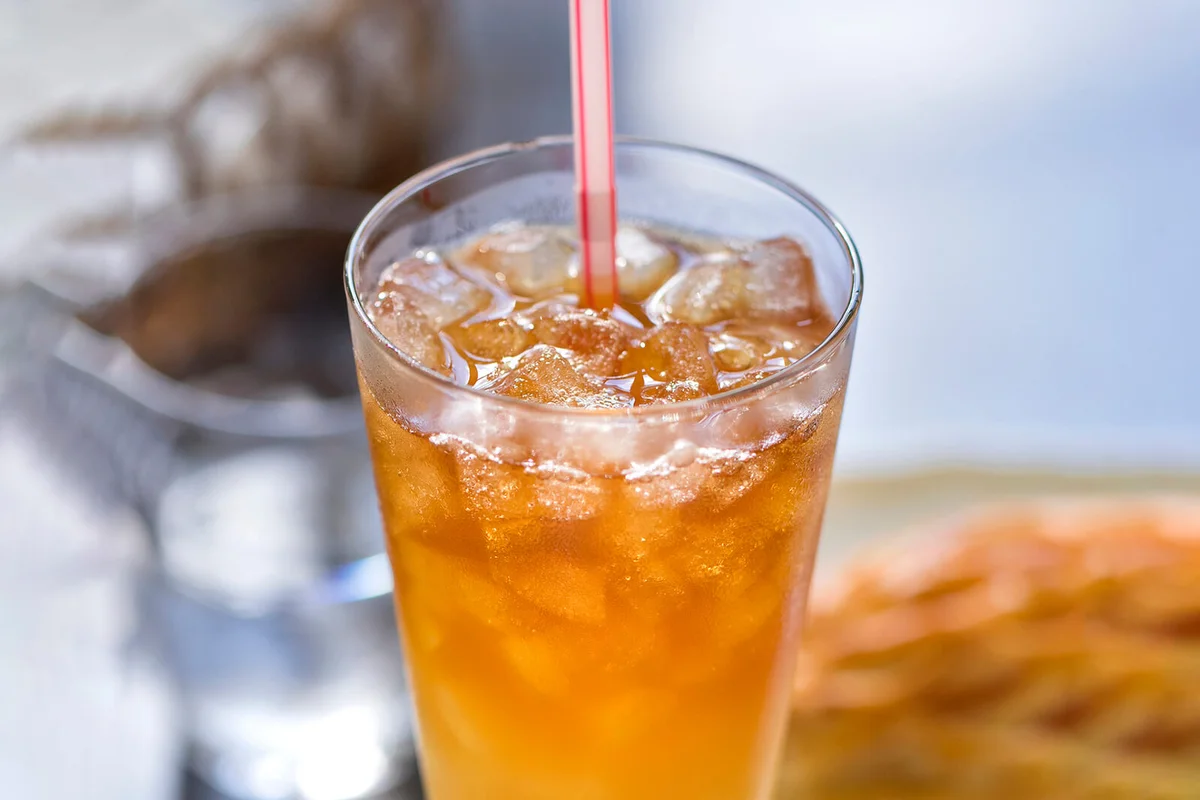 Ice apple juice in tall glass