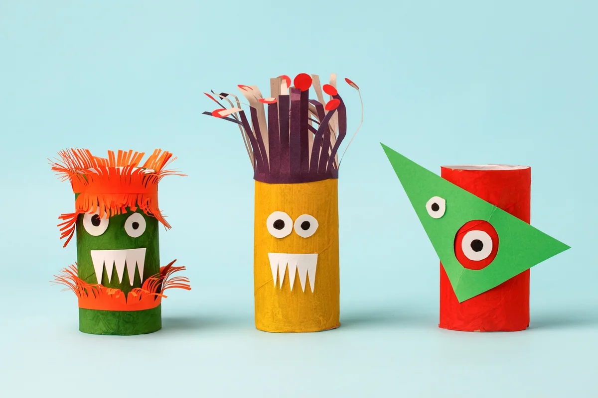 Close-Up Of Paper Roll Monsters Against Colored Background